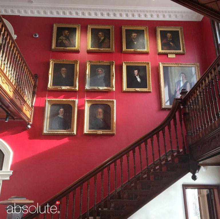 Stairwell at The Museum of Barnstaple & North Devon with wall-mounted portrait paintings secured using Absolute art hanging systems. 